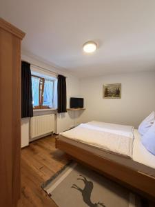 a bedroom with a bed and a television in it at Ferienwohnungen Größwang in Bischofswiesen