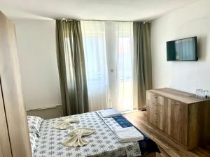 a bedroom with a bed with towels on it at Къща за гости ПЕРФЕКТО in Chernomorets +19 photos
