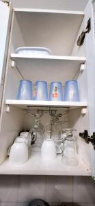 a shelf with cups and dishes in a refrigerator at Condotels at Albergo Hotel Baguio in Baguio