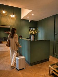a woman walking with a suitcase in a lobby at Boutique Hotel Roma 30 in Trescore Balneario