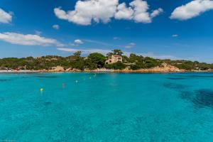 a view of a beach with a house in the water at bilocale vista porto in Cannigione