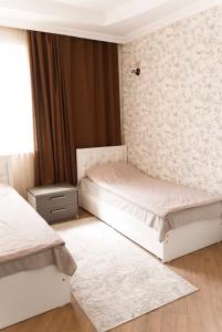 a bedroom with two beds and a wall at Роща 7 in Bishkek