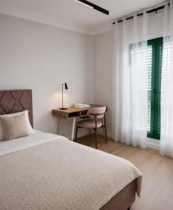 a bedroom with a bed and a desk and a table at Villa AdriaBelle in Tivat