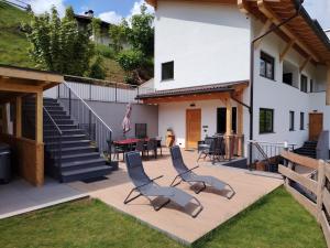 a patio with two chairs and a table and stairs at MOUNTAIN DELUXE 27 APARTMENTS con WELLNESS in Cavalese