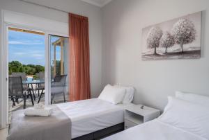 a bedroom with two twin beds and a balcony at Studios Maximo in Karavádhos +73 photos
