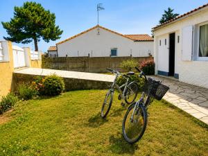 two bikes parked in a yard next to a house at Séjour bercé par la Mer in Jard-sur-Mer