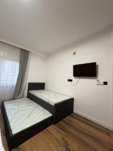 a bedroom with a bed and a flat screen tv at Home City Center - 3BedR & 3BathR - Free Private Parking in Prishtinë