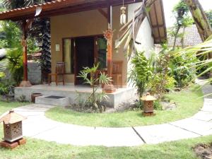 a house with a porch and a walkway in front at Toke Menjangan in Banyuwedang