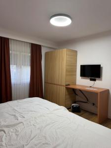 a bedroom with a bed and a desk with a television at Home City Center - 3BedR & 3BathR - Free Private Parking in Prishtinë