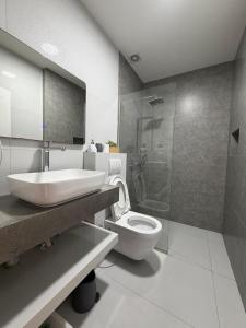 a bathroom with a sink and a toilet and a shower at Home City Center - 3BedR & 3BathR - Free Private Parking in Prishtinë +10 photos