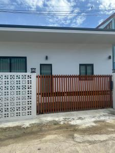 a white house with a wooden fence in front of it at Beas Boutique House Khlong Dow in Ko Lanta
