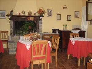 a dining room with two tables and a fireplace at La Piana Dei Castagni in Castel dʼAiano +47 photos