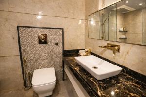 a bathroom with a white toilet and a sink at Airport NH Skye Suites Hotel Terminal 3, Delhi International Airport With - Free Airport Pickup in New Delhi +31 photos