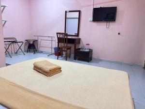 a room with a bed and a mirror and a tv at Huda Inn in Pantai Cenang