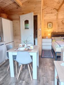 a dining room and kitchen in a log cabin with a table and chairs at Letniak pod Dębami in Grabina