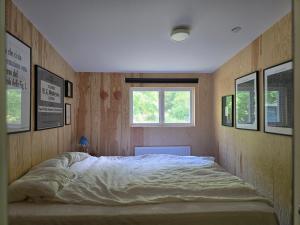 a bedroom with a large bed with a window at Malenasro in Karlshamn