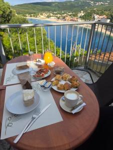 a table with plates of food and a cup of coffee at Paraskevi's Luxury Studios in Parga