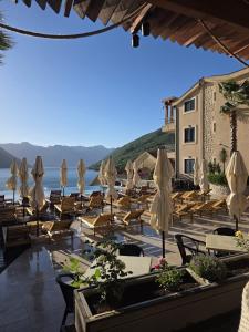a group of tables and chairs with umbrellas at Bellezza Residence & Spa Kotor in Donji Morinj