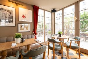 a restaurant with two tables and chairs and windows at Mondrian Suites Berlin am Checkpoint Charlie in Berlin