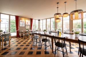a dining room with tables and chairs and windows at Mondrian Suites Berlin am Checkpoint Charlie in Berlin