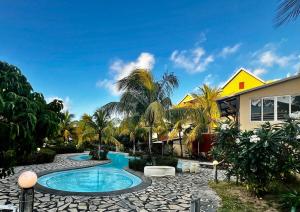 a swimming pool in front of a house at Little Palm Studio in Cap Malheureux