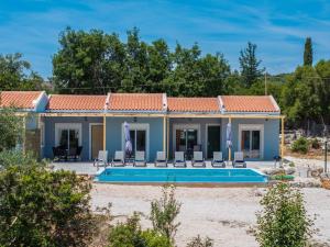 a villa with a swimming pool and a house at Studios Maximo in Karavádhos