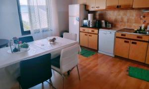 a kitchen with a table and chairs and a white refrigerator at Apartman Arija-Pino in Vodice +40 photos