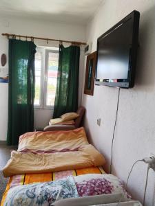 two beds in a room with a flat screen tv on the wall at Ogi in Straševina