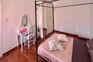 a bedroom with a bed and a mirror and a chair at Apartamento "El Casco Antiguo" in Xàtiva