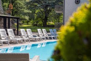 a row of chairs sitting next to a swimming pool at Residence CATULLO in Bezzecca