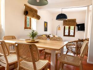 a dining room with a wooden table and chairs at La casina de Barro in Llanes