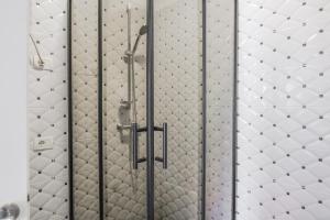 a shower in a bathroom with white tiled walls at Hotel Maresol Accommodation in Shëngjin +133 photos