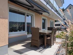 a patio with a table and chairs on a balcony at Ferienwohnung zum Bätstän in Pluwig