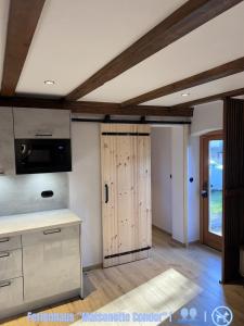a kitchen with a wooden door in a room at Seeblick Cottage in Ziemitz