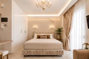 a bedroom with a large bed and a chandelier at GOLDENSPACE by Evagelias Homes Volos in Volos +6 photos