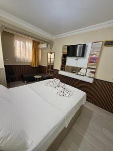 a bedroom with a large white bed and a television at Exporoyal Hotel in Antalya