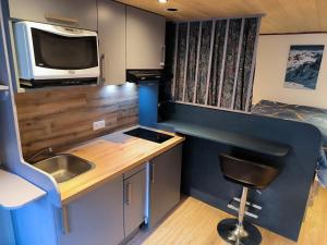 a kitchen with a sink and a desk and a tv at Cozy studio in a mountain village in Villar-dʼArène