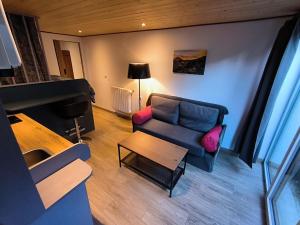 a living room with a couch and a piano at Cozy studio in a mountain village in Villar-dʼArène