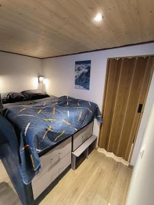 a bedroom with a bed with a blue comforter at Cozy studio in a mountain village in Villar-dʼArène