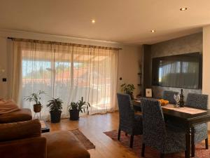 a living room with a dining room table with chairs at Apartman Jesenjin Pobri in Volosko