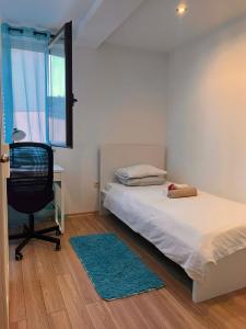 a bedroom with a bed and a desk and a chair at Apartman Jesenjin Pobri in Volosko