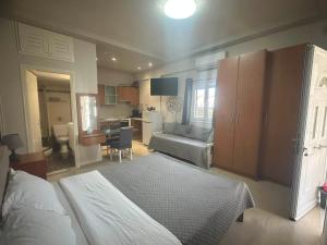 a bedroom with a bed and a couch and a kitchen at Angeligue Studio with Balcony in Ipsos
