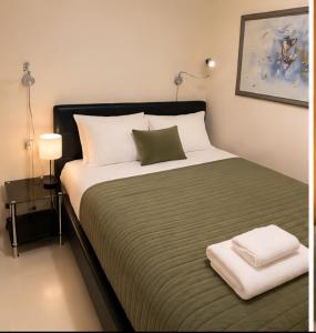 a bedroom with a large bed with a green blanket at Hobart city hotel in Hobart