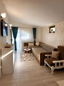 a living room with a bed and a couch at Casuta Irinei in Gura Vadului