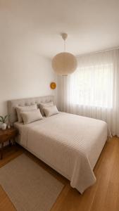 a bedroom with a large white bed with a large window at Valeri Lux Becici in Rafailovici