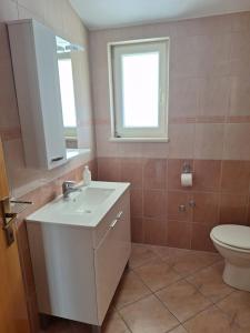 a bathroom with a white sink and a toilet at Apartments Primosten in Primošten +53 photos