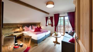 a bedroom with a bed with red pillows and a couch at Ludlalm am Prebersee in Tamsweg