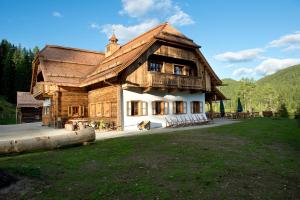 a large wooden house with a dog in front of it at Ludlalm am Prebersee in Tamsweg