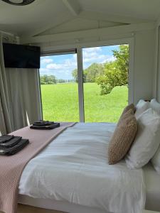 a bedroom with a bed with a view of a field at benbmeestervankampen in Oosterwolde