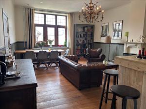 a living room with a couch and a table and chairs at B&B Les Soigneurs in Grandmenil